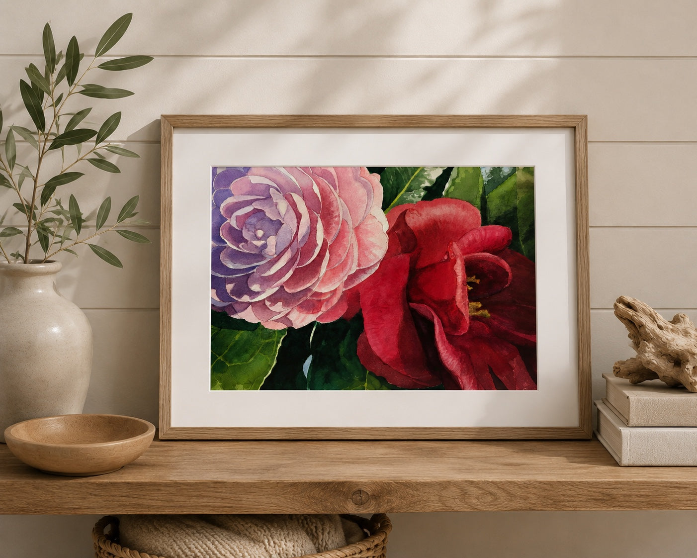 Framed artwork of pink and red flowers on a wooden shelf with decorative items.